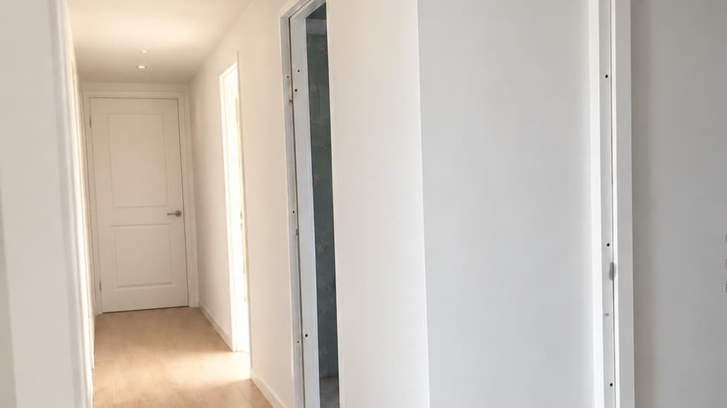 Fertiger Flur mit glatt verputzten Wänden und Decke und einer Tür am Ende