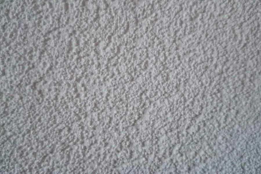 Close-up of textured plaster on a wall: a rough, even grain structure